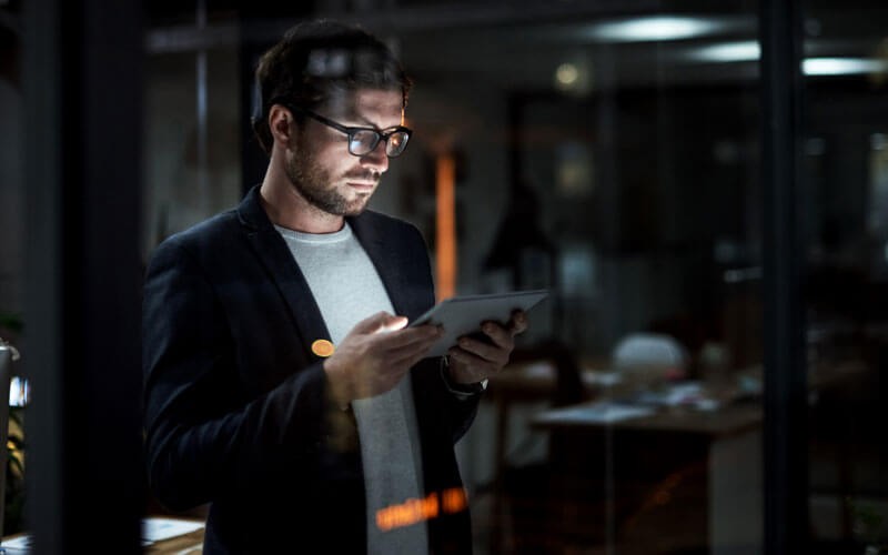 Man using tablet device late at night in office